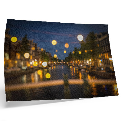 Poster em tela Uma cidade encantadora à noite, com luzes refletidas na água.