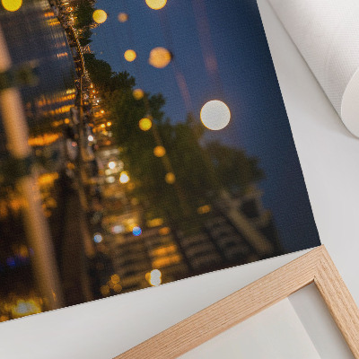 Poster em tela Uma cidade encantadora à noite, com luzes refletidas na água.