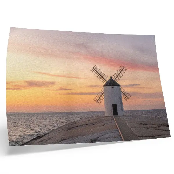 Poster mural moinho de vento ao pôr do sol no mar com céu em tons pastel