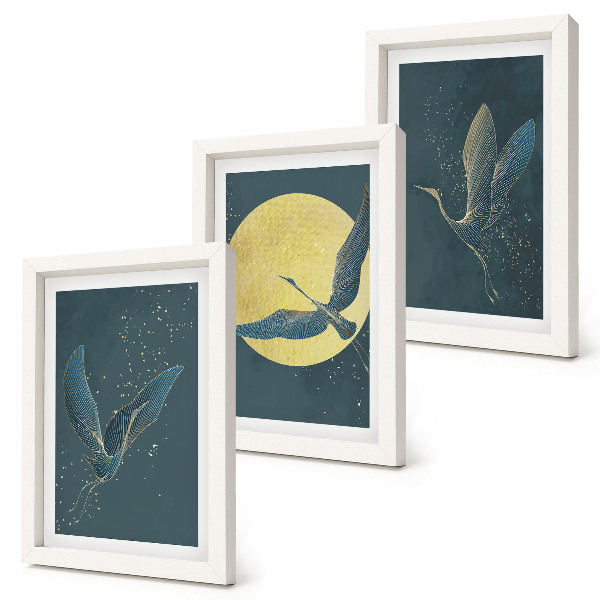 Conjunto de 3 quadros decorativos Garças em voo contra o pano de fundo da lua e das estrelas.