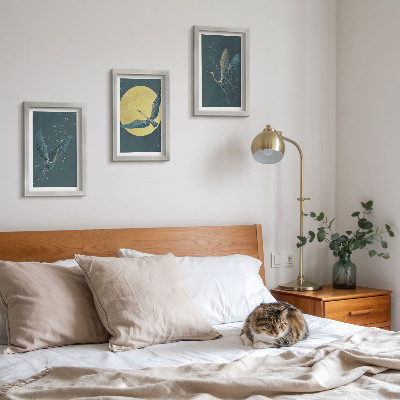 Conjunto de 3 quadros decorativos Garças em voo contra o pano de fundo da lua e das estrelas.