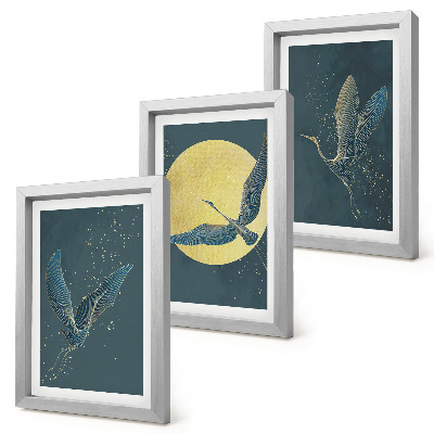 Conjunto de 3 quadros decorativos Garças em voo contra o pano de fundo da lua e das estrelas.