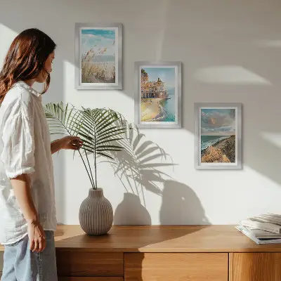 Conjunto de 3 quadros decorativos com paisagens litorâneas de praia, cidade e falésias