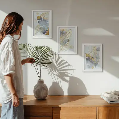 Conjunto de 3 quadros decorativos com estampas de folhas em tons de azul e bege sobre fundo claro