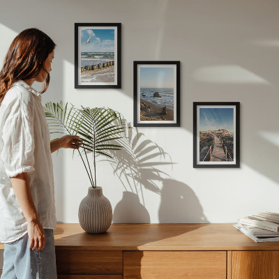 Conjunto de 3 quadros decorativos Vista da praia com ondas, céu e um píer para pedestres.
