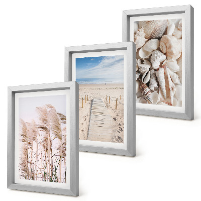 Tríptico com moldura Praia de areia com conchas e ervas marinhas.