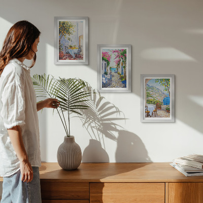 Tríptico com moldura Ruas encantadoras com plantas floridas e vista para o mar.