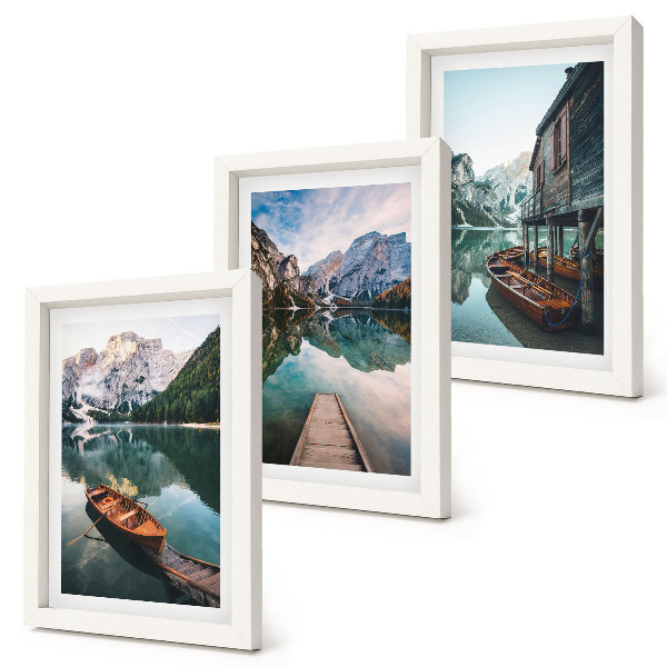 Conjunto de 3 quadros decorativos Um lago nas montanhas com barcos e uma cabana de madeira.