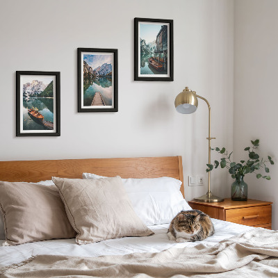 Conjunto de 3 quadros decorativos Um lago nas montanhas com barcos e uma cabana de madeira.