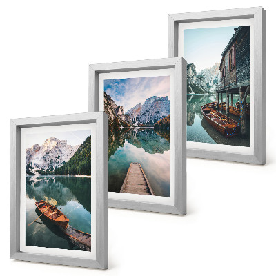 Conjunto de 3 quadros decorativos Um lago nas montanhas com barcos e uma cabana de madeira.