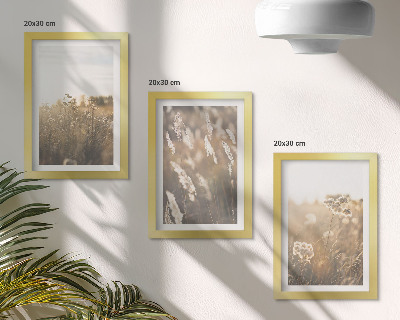 Conjunto de 3 quadros decorativos Uma paisagem com gramíneas e flores em tons quentes.